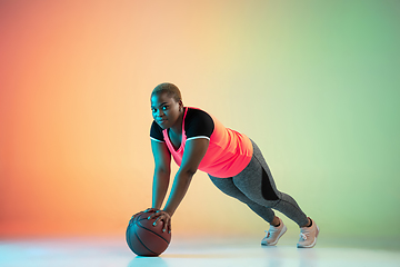 Image showing Young african-american plus size female model\'s training on gradient background