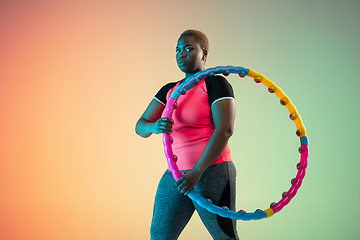 Image showing Young african-american plus size female model\'s training on gradient background