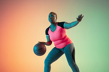 Image showing Young african-american plus size female model\'s training on gradient background