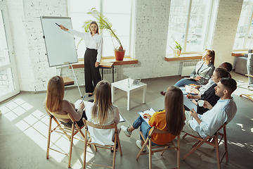 Image showing Female caucasian speaker giving presentation in hall at university or business centre workshop