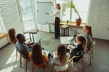 Image showing Female caucasian speaker giving presentation in hall at university or business centre workshop