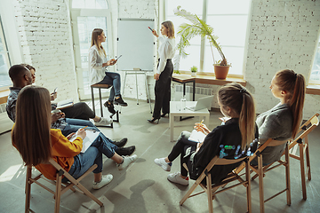 Image showing Female caucasian speaker giving presentation in hall at university or business centre workshop