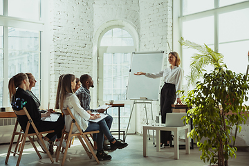 Image showing Female caucasian speaker giving presentation in hall at university or business centre workshop