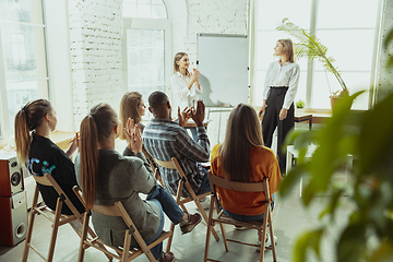 Image showing Female caucasian speaker giving presentation in hall at university or business centre workshop