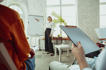 Image showing Female caucasian speaker giving presentation in hall at university or business centre workshop