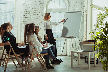 Image showing Female caucasian speaker giving presentation in hall at university or business centre workshop