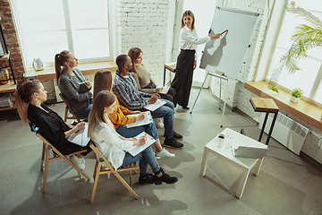 Image showing Female caucasian speaker giving presentation in hall at university or business centre workshop