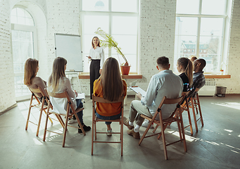 Image showing Female caucasian speaker giving presentation in hall at university or business centre workshop