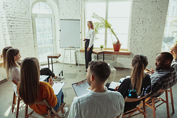 Image showing Female caucasian speaker giving presentation in hall at university or business centre workshop