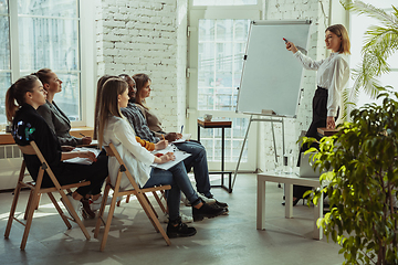 Image showing Female caucasian speaker giving presentation in hall at university or business centre workshop