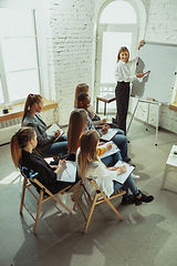 Image showing Female caucasian speaker giving presentation in hall at university or business centre workshop