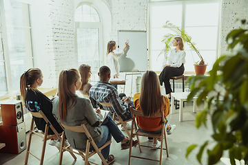 Image showing Female caucasian speaker giving presentation in hall at university or business centre workshop