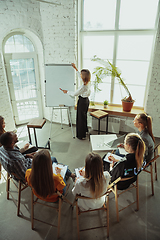 Image showing Female caucasian speaker giving presentation in hall at university or business centre workshop