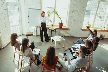 Image showing Female caucasian speaker giving presentation in hall at university or business centre workshop