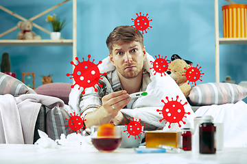 Image showing Young man scared of coronavirus spreading and worldwide cases, feeling ill, sick, fever
