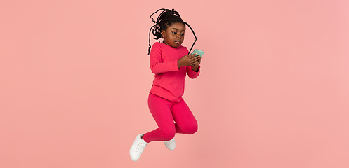 Image showing Handsome african little girl portrait isolated on pink studio background with copyspace