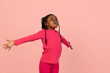 Image showing Handsome african little girl portrait isolated on pink studio background with copyspace