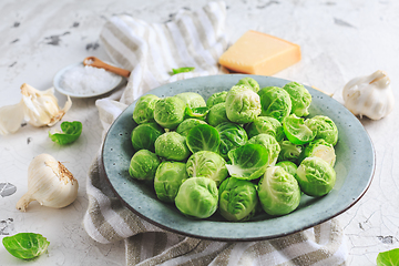 Image showing Raw Brussel sprouts with salt and Parmesan cheese in bowl