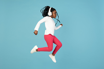 Image showing Handsome african little girl portrait isolated on blue studio background with copyspace