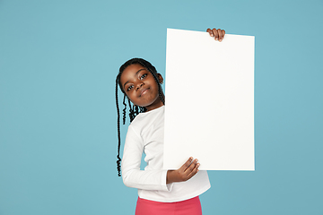 Image showing Handsome african little girl portrait isolated on blue studio background with copyspace