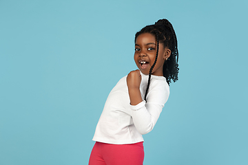 Image showing Handsome african little girl portrait isolated on blue studio background with copyspace