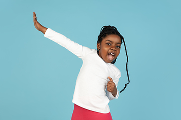 Image showing Handsome african little girl portrait isolated on blue studio background with copyspace