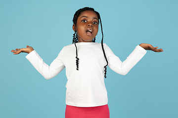 Image showing Handsome african little girl portrait isolated on blue studio background with copyspace