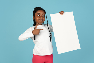 Image showing Handsome african little girl portrait isolated on blue studio background with copyspace