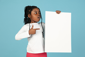 Image showing Handsome african little girl portrait isolated on blue studio background with copyspace