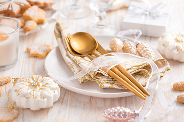 Image showing Place setting and Christmas table decorated with ornaments, gingerbread and cookies