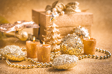 Image showing Christmas ornaments, present box and candles in golden tones