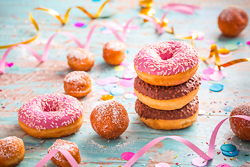 Image showing Krapfen, Berliner and donuts with streamers and confetti. Colorful carnival or birthday image