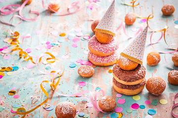 Image showing Krapfen, Berliner and donuts with streamers and confetti. Colorful carnival or birthday image