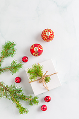 Image showing Christmas composition. Christmas gift, fir branches on wooden white background. Flat lay, top view, copyspace