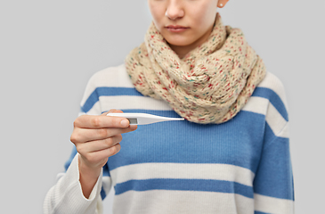 Image showing sick teenage girl in scarf measuring temperature