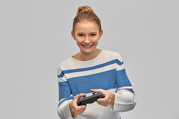 Image showing happy teenage girl with gamepad playing video game
