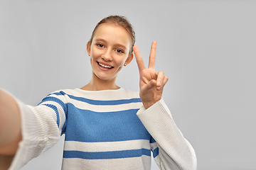 Image showing happy teenage girl taking selfie and showing peace