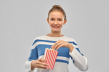 Image showing smiling teenage girl eating popcorn