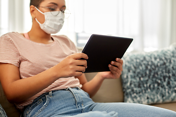 Image showing woman in medical mask with tablet pc at home