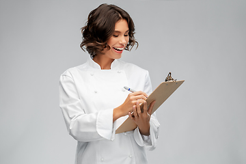 Image showing smiling female chef in toque with clipboard