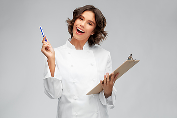 Image showing smiling female chef in toque with clipboard