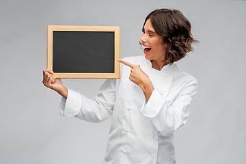 Image showing smiling female chef holding black chalkboard