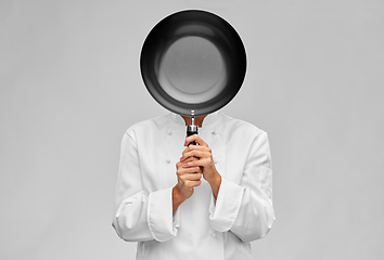 Image showing female chef covering her face with frying pan