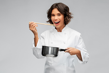 Image showing happy female chef with saucepan tasting food