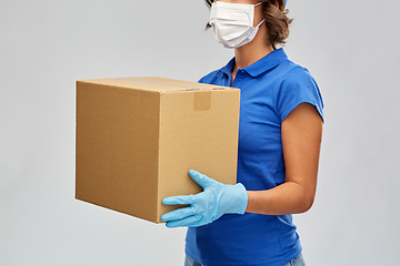 Image showing delivery woman in face mask holding parcel box