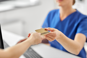 Image showing patient giving doctor credit card at hospital