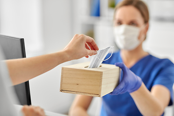 Image showing doctor offering mask to patient at hospital