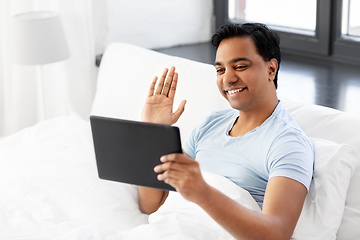 Image showing happy man with tablet pc in bed having video call