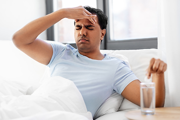 Image showing sick man in bed with medicine and glass of water