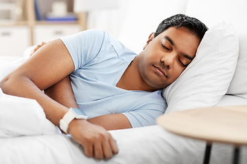 Image showing indian man with smart watch sleeping in bed